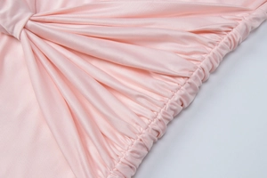 Detail of light pink ruched fabric with professional stitching and elastic texture