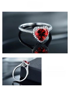 Macro detail of S925 silver heart ring featuring a red gemstone and halo diamond setting