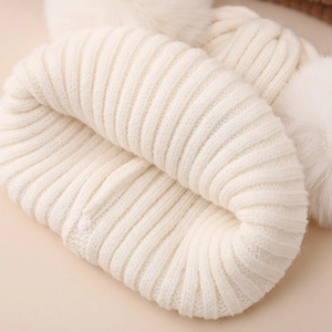 Cozy cream knit winter hat for girls featuring two fluffy pom-poms and warm ribbing