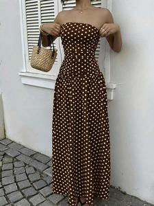 Detailed close-up of brown polka dot strapless maxi dress with flowing fabric texture