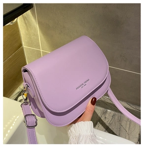 Dettaglio della borsa a sella in similpelle viola con fibbia argentata e stampa moda