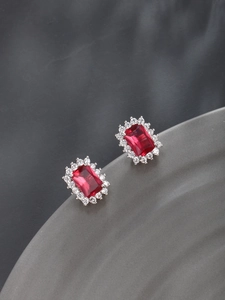 Detail of elegant red rectangle zircon earrings with white crystal halo border