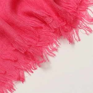 Detailed macro view of rose red cotton linen scarf texture with dense tassel edge