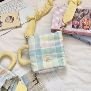 Detailed view of checkered crossbody water bottle bag with soft handle and adjustable strap