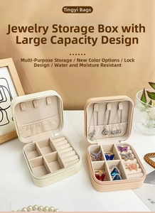 Detail of portable PU jewelry box showing ring slots and necklace hooks in beige and pink