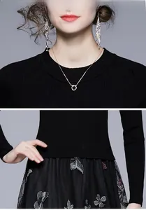 Dettagli del ricamo a farfalla su abito in maglia nero con primo piano della trama