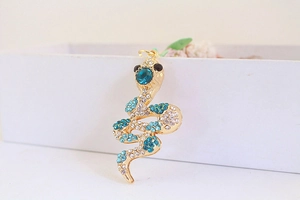 Macro view of gold snake keychain with sparkling white and blue crystals and rhinestones