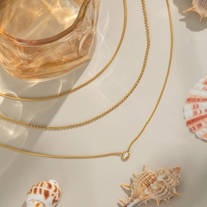 Détail du collier triple rang plaqué or 18K avec pendentif zircon et décor de coquillages