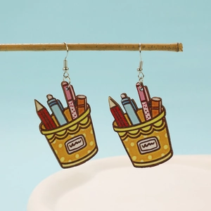Detalle de pendientes coloridos de madera con diseño de papelería sobre una rama