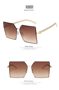 Detail view of large square sunglasses with brown gradient lenses and gold chain temples