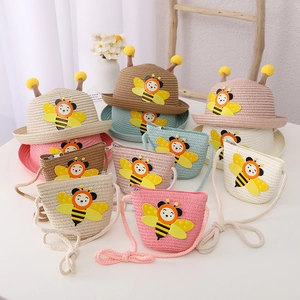 Detail of woven straw sun hat and matching crossbody bag with cute 3D cartoon bee design