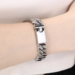 Gros plan d'un bracelet gourmette argenté avec plaque rectangulaire sur un poignet