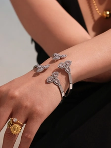 Detail of 18k gold plated clover bracelet with 5A zircons and stacked fashion rings
