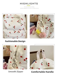 Detail of white corduroy backpack with cherry pattern and fuzzy heart keychain