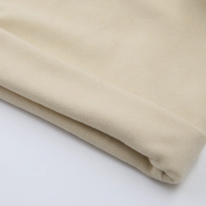 Macro shot of soft beige knit fabric detail with smooth texture for baby winter hat