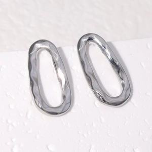 Macro detail of silver stainless steel earrings featuring an irregular ripple texture finish