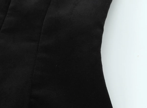 Détail des coutures du tissu noir haute densité sur la robe courte évasée