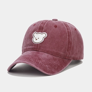 Close-up of vintage washed pink baseball cap with cute white bear embroidery
