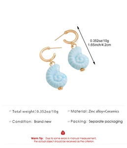 Détails de boucles d'oreilles conque en céramique bleu clair avec crochets dorés