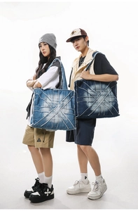 Detail of large denim tote bags with raw edge star stitching in light and dark blue wash