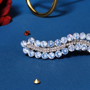 Detailed close-up of a silver hair clip with sparkling blue and clear zircon crystals