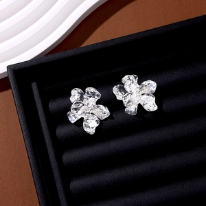 Detailed view of silver irregular liquid metal flower earrings on black velvet display
