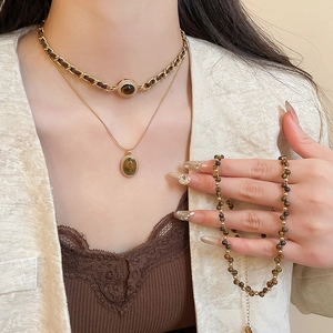 Dettaglio del set di gioielli in oro 18k e occhio di tigre indossato dalla modella