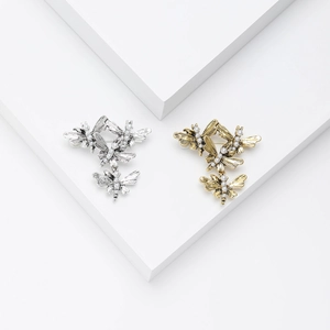 Vintage style gold and silver butterfly cluster brooches with small pearls on white base