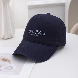 Casquette de baseball en coton bleu marine avec broderie sur un bureau blanc