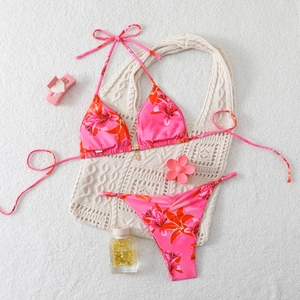 Close-up of pink floral bikini set with halter neck ties and metal charms details