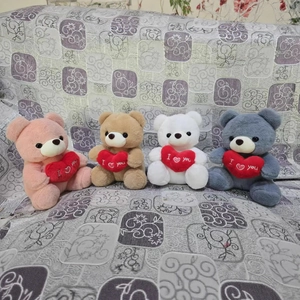 Ositos de peluche rosa, blanco y gris con corazones rojos de I Love You en sofá