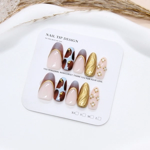 Handmade press-on nails with 3D gold accents and sparkling crystals on long round tips