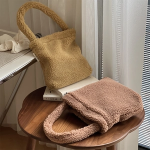 Detailed view of yellow and pink faux fur tote bags on a wooden table with cozy lighting