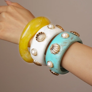 Detailed macro view of resin bangles featuring marble textures and faux pearl accents