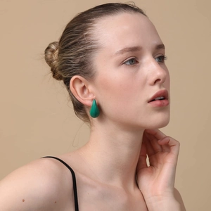 Close-up of a model wearing the green teardrop earring with a smooth enamel finish