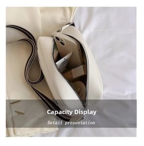 Internal view of white litchi leather crossbody bag with striped strap and personal items