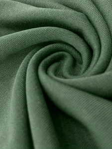 Macro shot of dark green ribbed knit fabric texture with fine spiral texture details