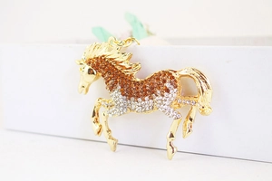 Detailed view of horse-shaped metal keychain with brown and clear rhinestones