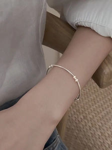 Minimalist silver beaded bracelet shown on a wrist with an elegant and refined look
