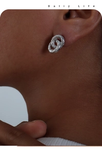 Detail of silver double hoop earrings with cubic zirconia inlay on a model ear
