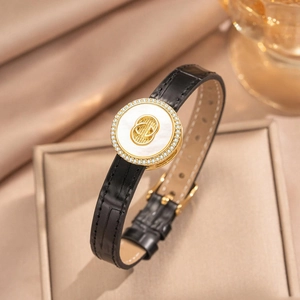 Elegant black crocodile leather bracelet with gold metal accent and inlaid crystals