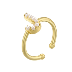 Close-up of elegant gold ring with white pearl inlay and sophisticated metal texture