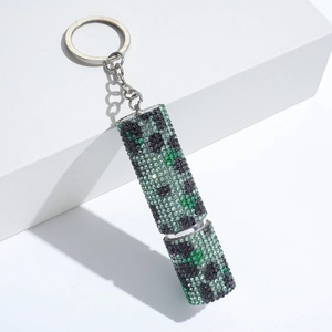 Macro detail of silver keychain featuring a sparkling green pixelated creeper design