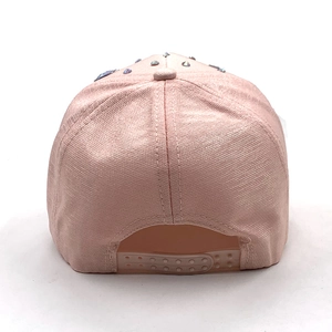 Close-up of pink baseball cap back featuring colorful rhinestones and adjustable plastic strap