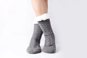 Detailed view of gray knit slipper socks featuring thick white faux fur fleece lining