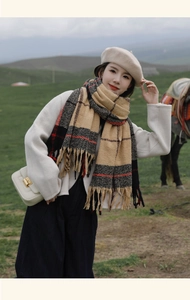 Close-up of a warm plaid scarf with soft tassels against a natural landscape