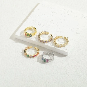 Detailed macro view of 14K gold plated rings and ear cuffs with colorful marquise zircons