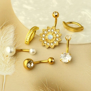 Detailed view of gold stainless steel navel rings with zircon, pearl, and floral designs
