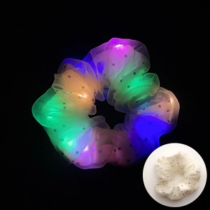 Détail du chouchou LED en résille avec lumières colorées et motif à pois noirs