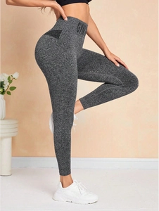 Détail du legging de yoga gris à taille haute avec logo GYM et texture sans couture